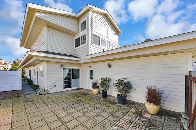 back of property with fence and a patio area