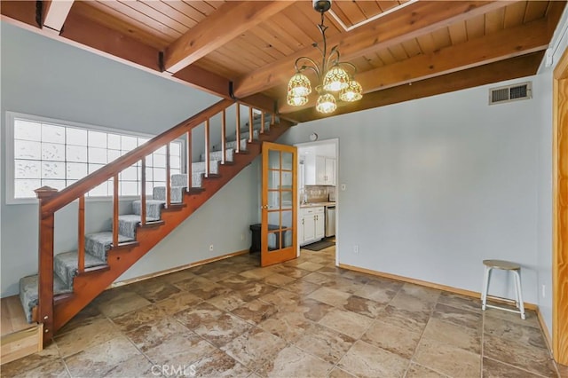 interior space featuring visible vents, baseboards, a chandelier, stairs, and beam ceiling