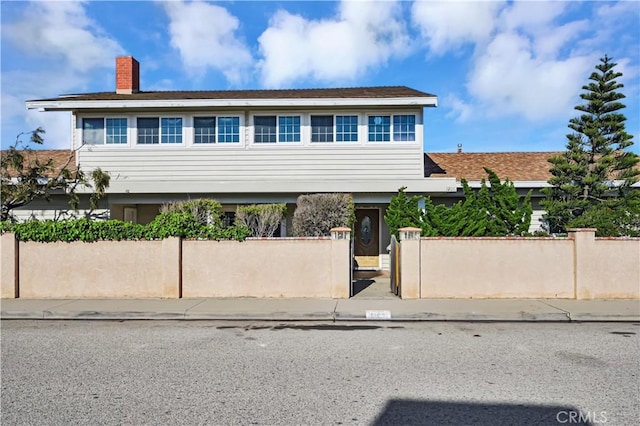 view of front of property featuring a fenced front yard and a chimney