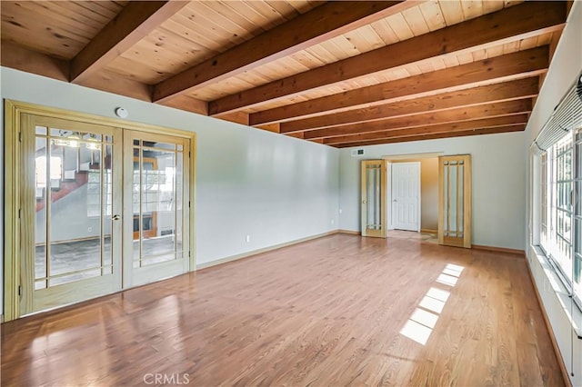 empty room featuring baseboards, beamed ceiling, french doors, wooden ceiling, and wood finished floors