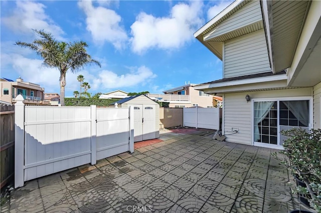 view of patio / terrace featuring an outdoor structure, a fenced backyard, and a shed