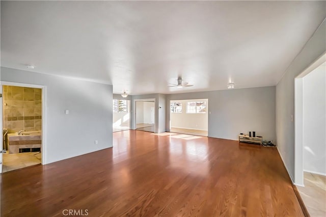 unfurnished living room with a ceiling fan and wood finished floors