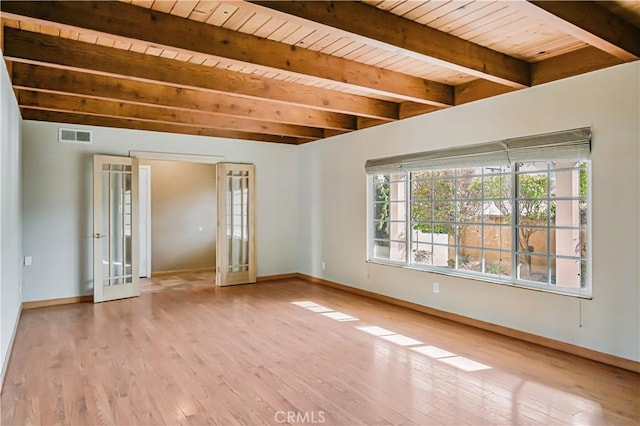 empty room featuring french doors, beam ceiling, visible vents, and hardwood / wood-style floors