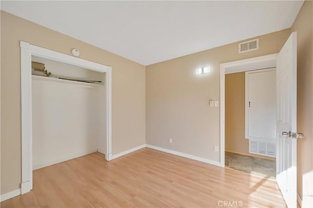 unfurnished bedroom featuring baseboards, visible vents, and light wood finished floors