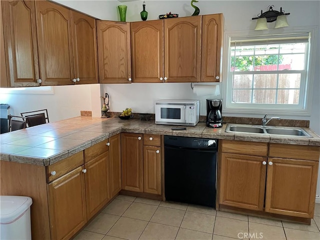 kitchen with a sink, light tile patterned flooring, dishwasher, and white microwave