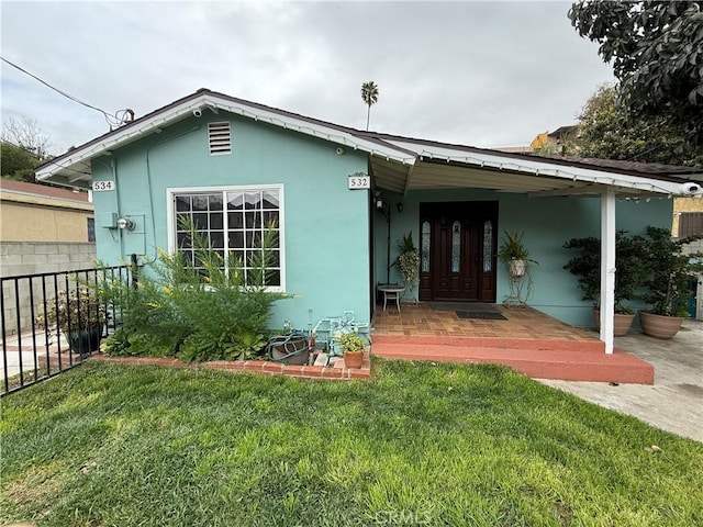 view of front facade featuring a front yard, fence, and stucco siding