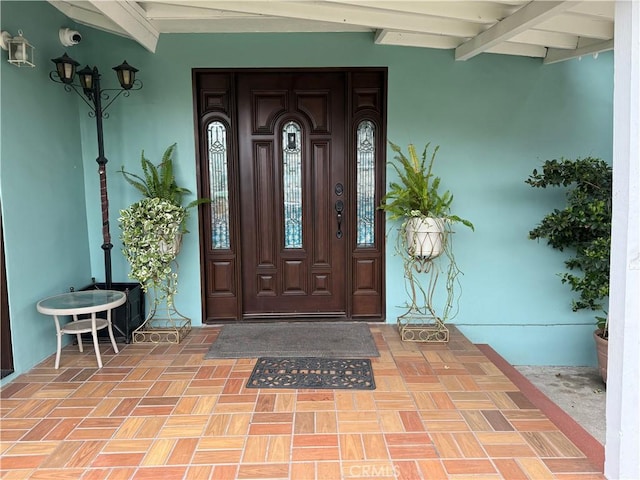 doorway to property featuring stucco siding