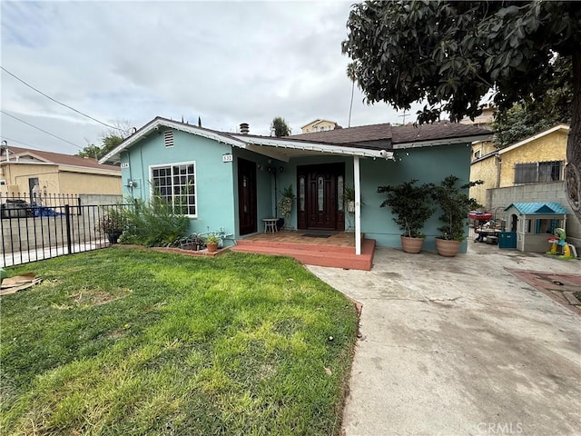 ranch-style house with a front lawn, fence, and stucco siding