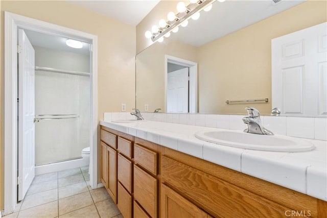 full bathroom with a sink, double vanity, a stall shower, and tile patterned floors