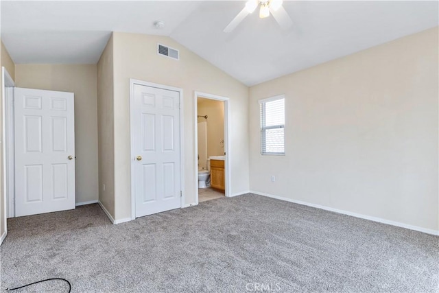 unfurnished bedroom with visible vents, baseboards, carpet, and vaulted ceiling