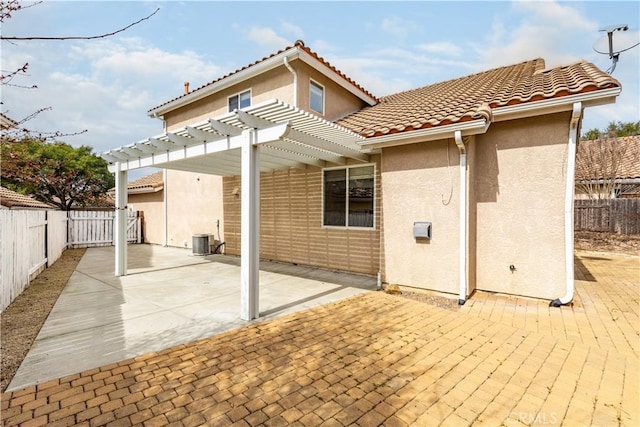 back of property with stucco siding, a pergola, a patio, a fenced backyard, and a tiled roof