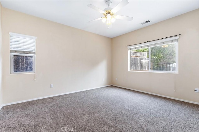 spare room with visible vents, baseboards, a ceiling fan, and carpet flooring