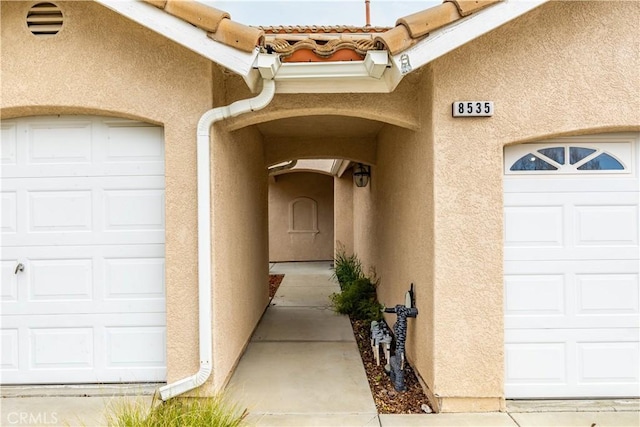 property entrance featuring stucco siding and a tile roof