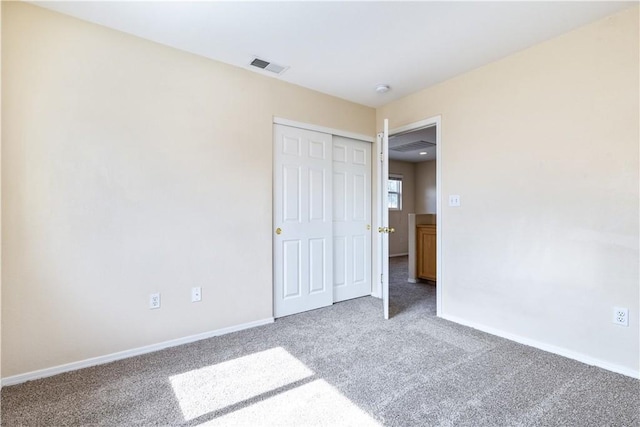 unfurnished bedroom with carpet, visible vents, a closet, and baseboards