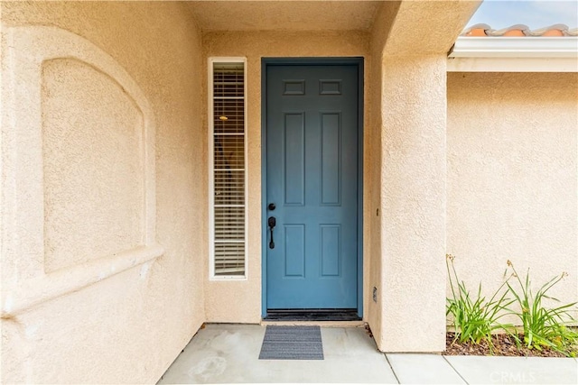 property entrance with stucco siding