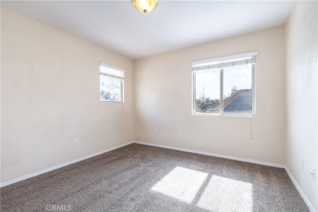 carpeted empty room with baseboards