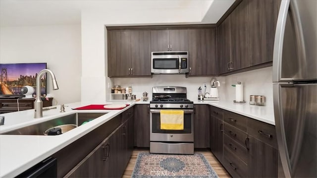 kitchen featuring a sink, dark brown cabinetry, appliances with stainless steel finishes, and light countertops