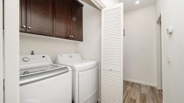 laundry area featuring baseboards, recessed lighting, cabinet space, washer and dryer, and light wood-type flooring