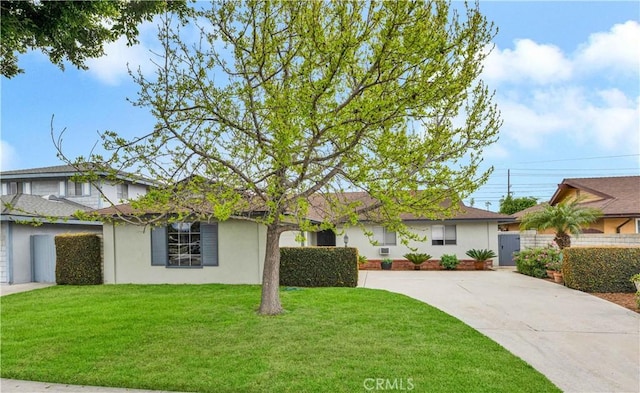 ranch-style home with stucco siding, driveway, a front yard, and fence