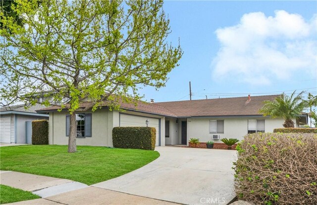 ranch-style house featuring a front lawn, an attached garage, driveway, and stucco siding