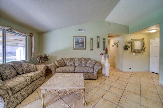 living room featuring light tile patterned flooring, visible vents, a textured ceiling, and vaulted ceiling