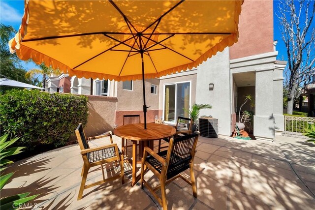 view of patio / terrace featuring outdoor dining area, central AC unit, and fence