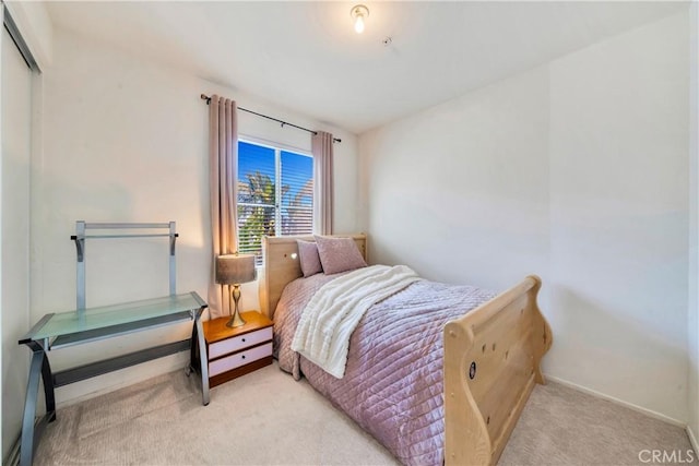 bedroom with light carpet and baseboards