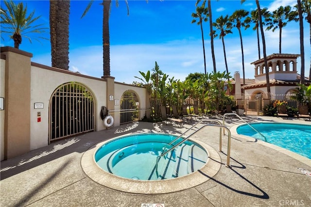 community pool featuring fence and a patio area