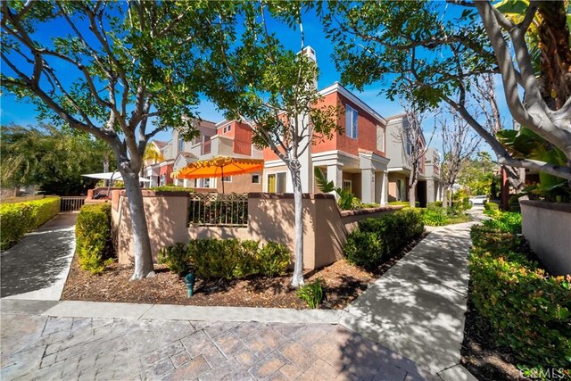 view of property exterior with a fenced front yard, a residential view, and stucco siding
