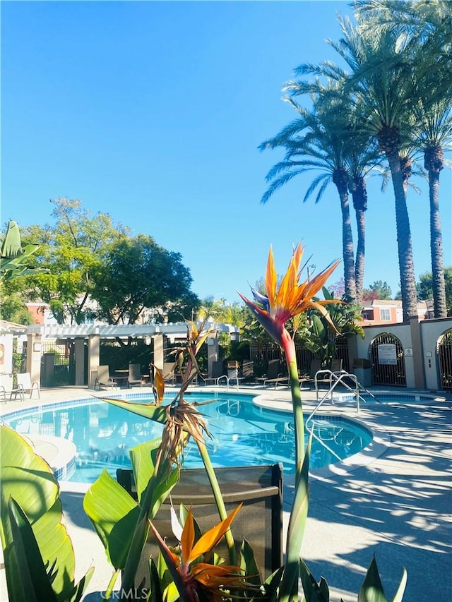 community pool featuring fence and a patio area