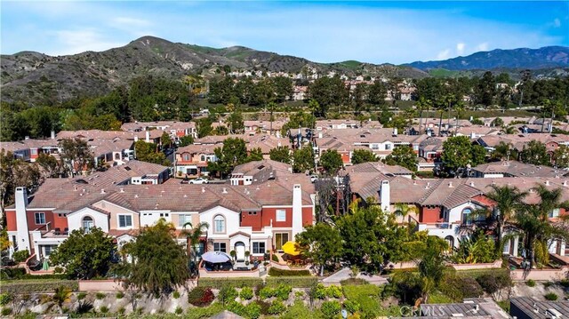 aerial overview of property's location with a mountainous background and nearby suburban area