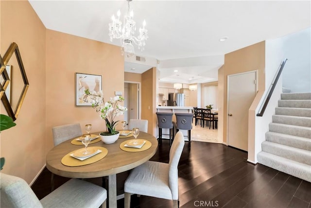 dining area with visible vents, dark wood-style floors, stairway, an inviting chandelier, and baseboards