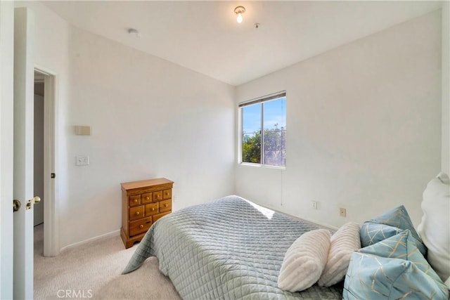 bedroom with baseboards and light colored carpet