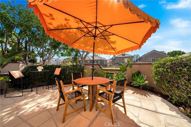 view of patio featuring outdoor dining area and fence