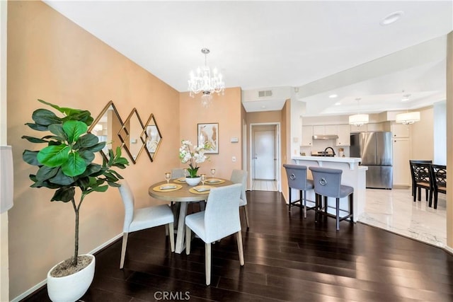 dining room with wood finished floors, a chandelier, baseboards, and recessed lighting