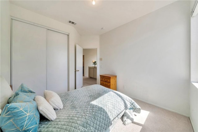 carpeted bedroom featuring a wall unit AC, baseboards, visible vents, and a closet