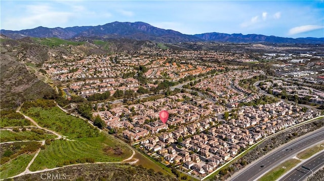 aerial view of property and surrounding area with nearby suburban area and a mountainous background