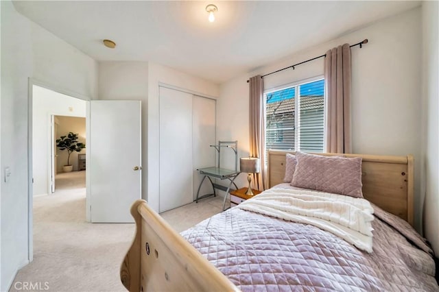 bedroom with a closet and light carpet