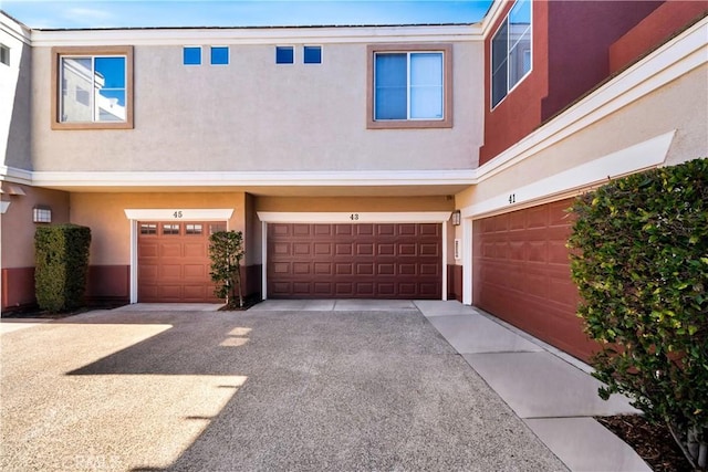 townhome / multi-family property featuring stucco siding, a garage, and driveway
