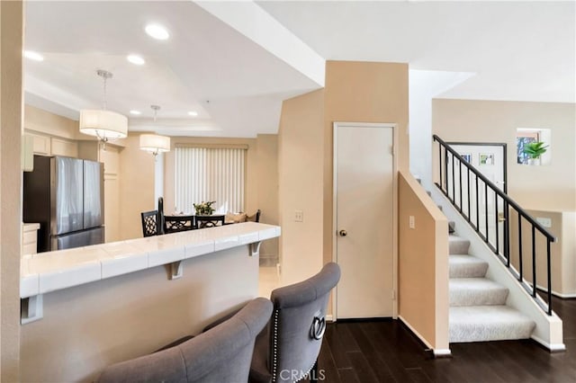 kitchen with freestanding refrigerator, tile countertops, dark wood-style floors, baseboards, and recessed lighting