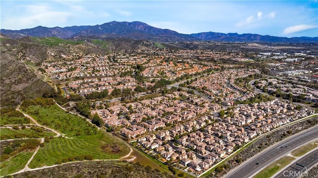 aerial view of property and surrounding area with nearby suburban area and mountains
