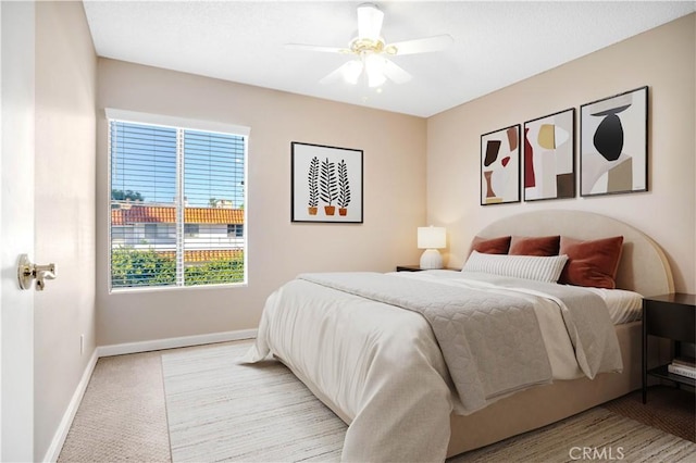 carpeted bedroom with a ceiling fan and baseboards