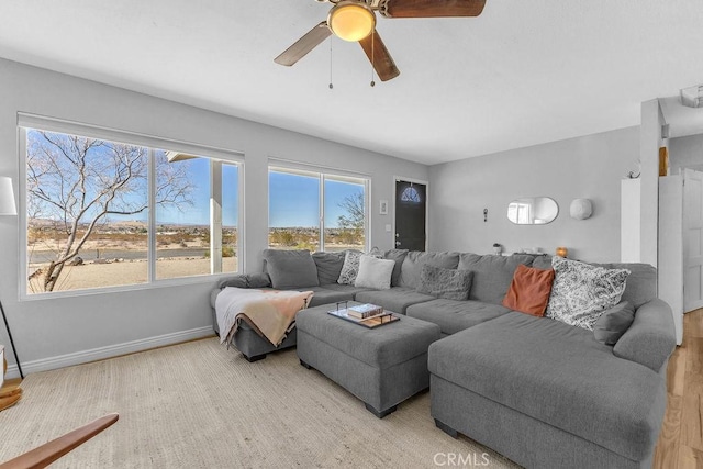 living room with ceiling fan and baseboards