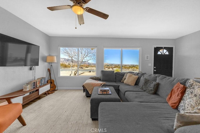 living room with ceiling fan and baseboards