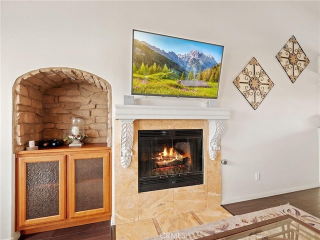 interior details with baseboards, a fireplace with flush hearth, and wood finished floors