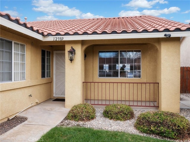 doorway to property with stucco siding and a tiled roof