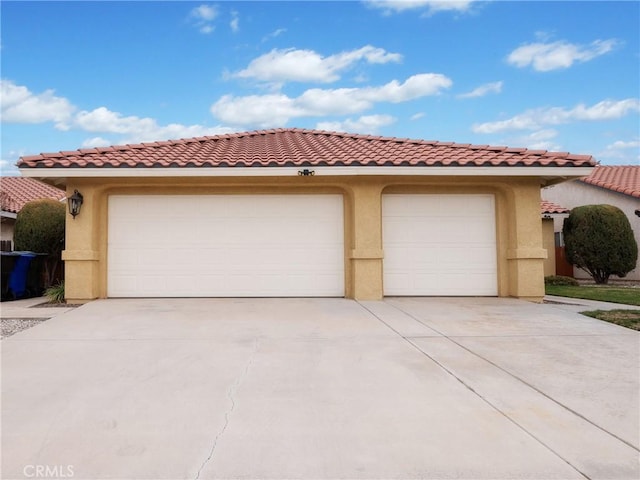 view of front of house with stucco siding, a tiled roof, and a garage