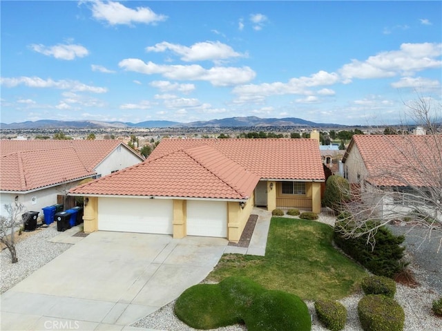 view of front of home with stucco siding, driveway, a mountain view, and a tile roof