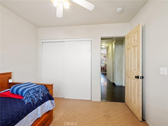 bedroom featuring a closet, light carpet, and ceiling fan