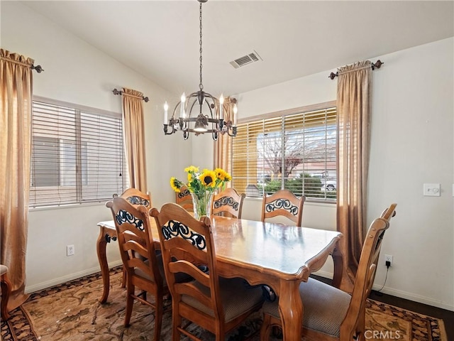 dining area featuring visible vents, lofted ceiling, baseboards, and a chandelier